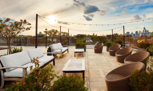 Find your perfect fit at Carroll Street a patio with chairs and tables and plants with a city in the background